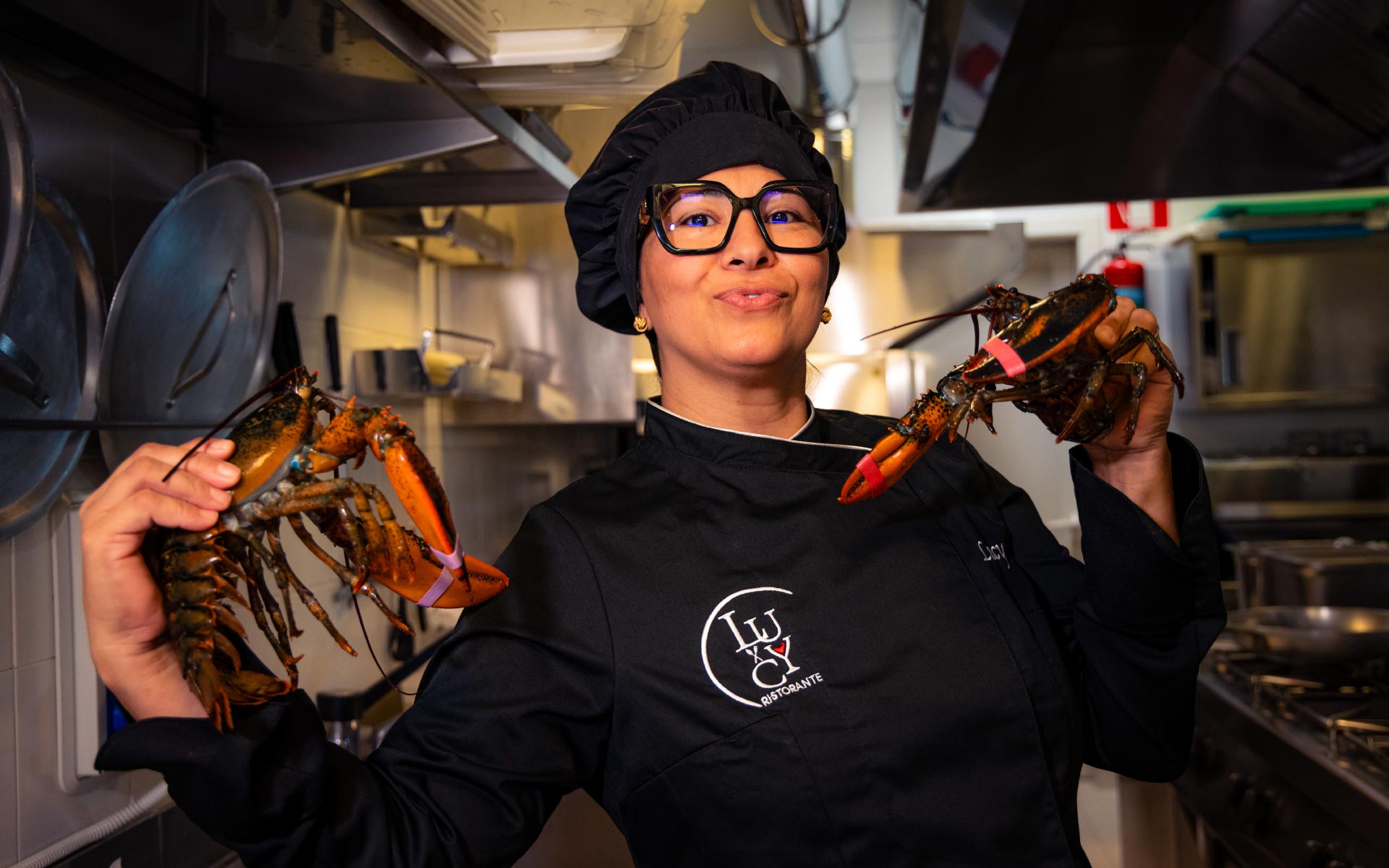 La chef Lucy mostra due astici freschi nella sua cucina