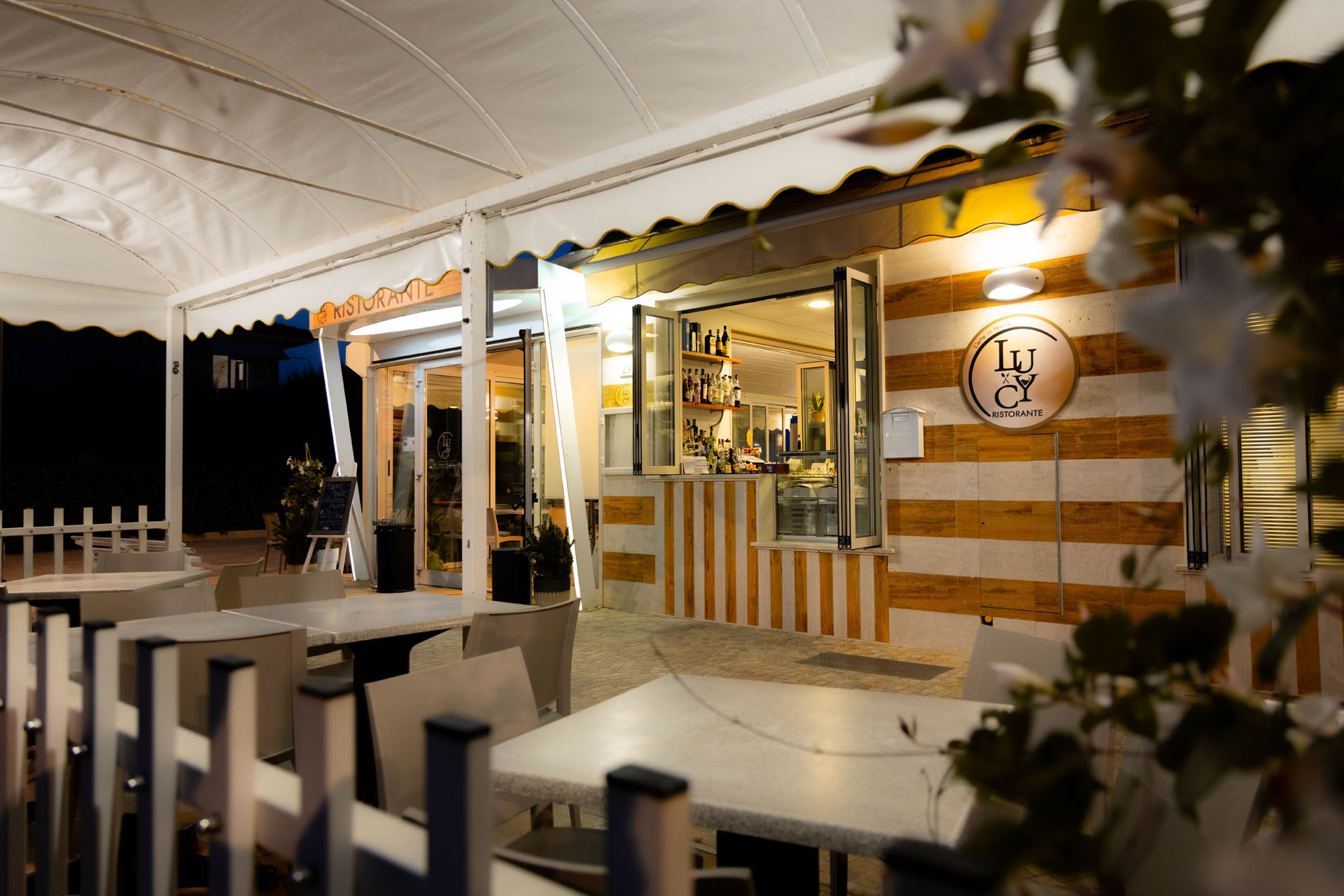 La terrazza del ristorante illuminata alla sera, con il logo Lucy