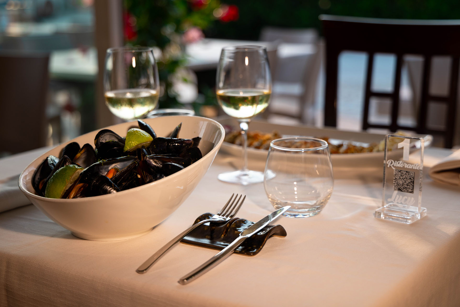 Cozze con limone accanto a un calice di vino bianco