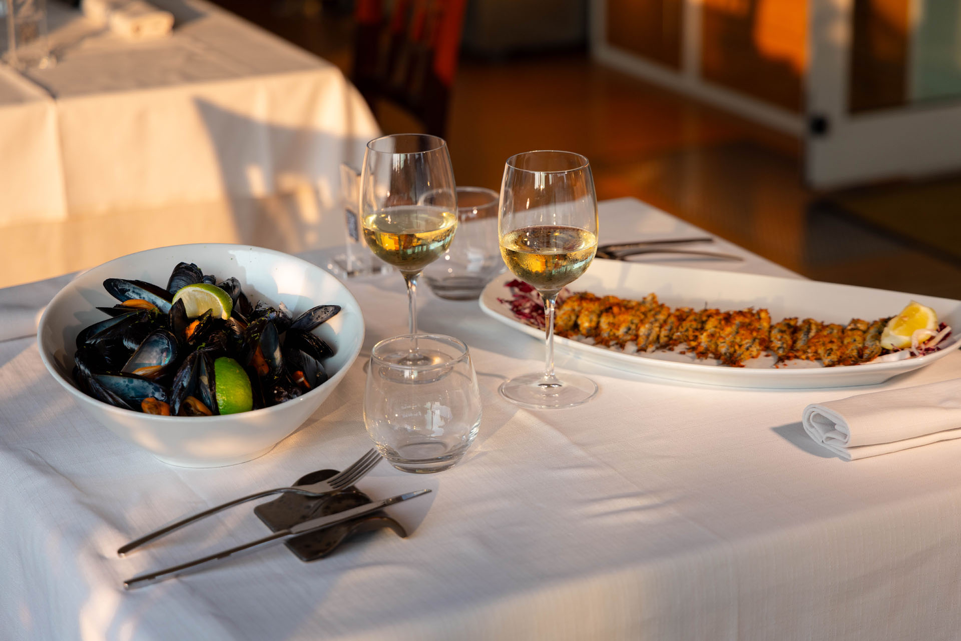 Cozze e piatto impanato sulla tavola apparecchiata