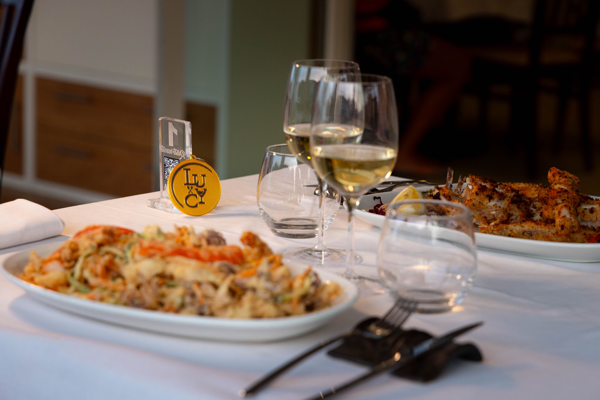 Pasta con frutti di mare e calici di vino sulla tavola