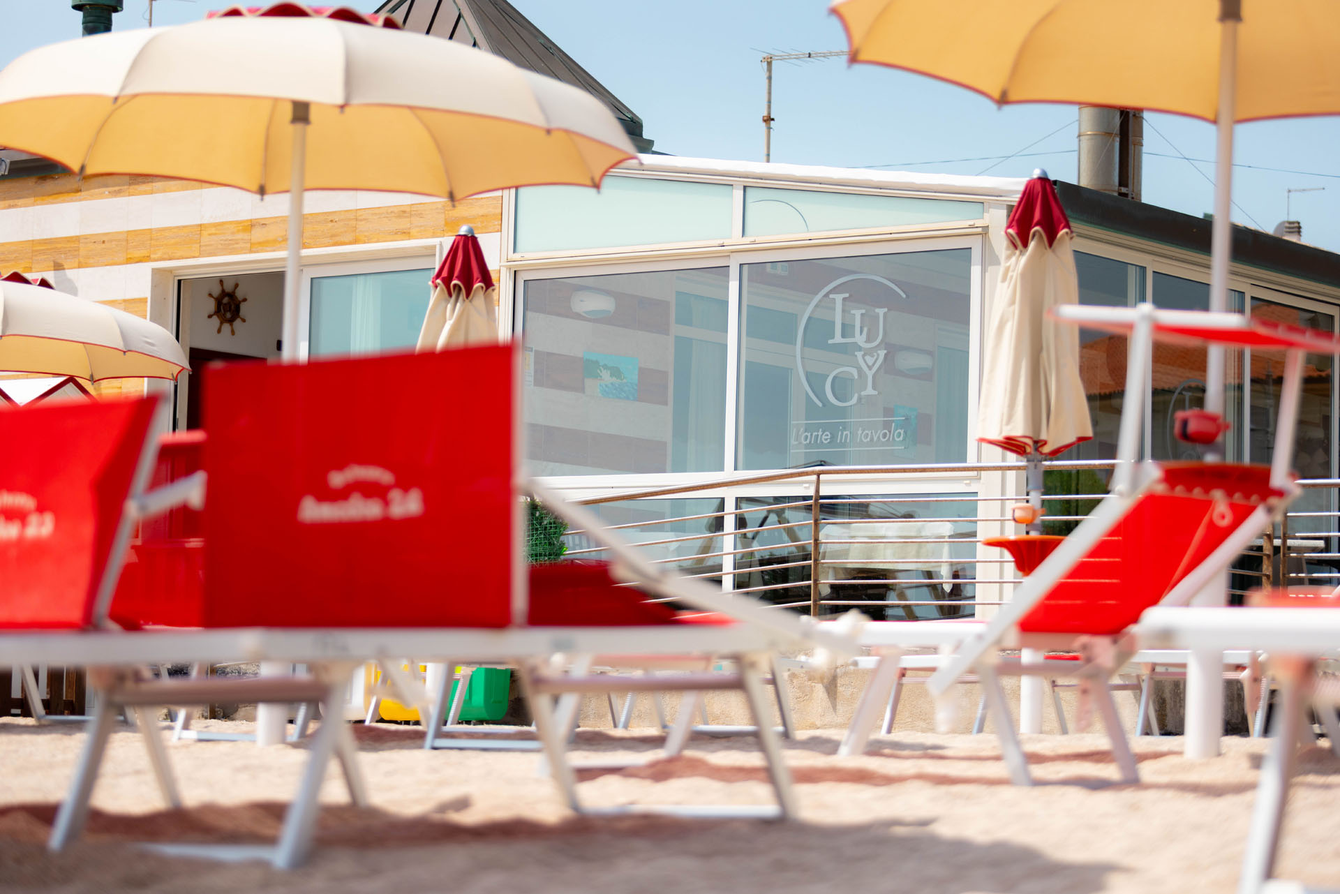 Lido con ombrelloni e lettini davanti al ristorante