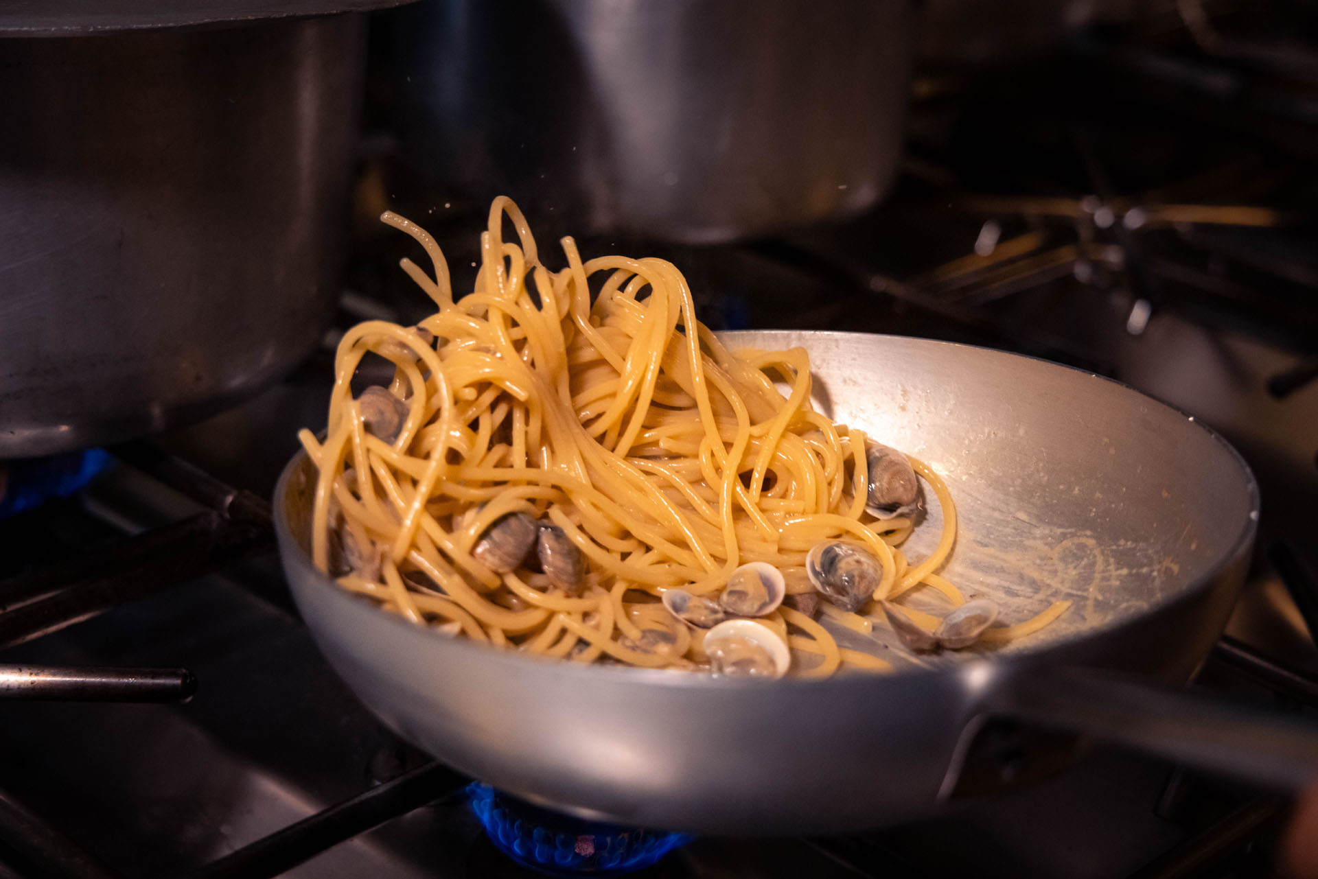 Spaghetti con vongole in padella sui fornelli