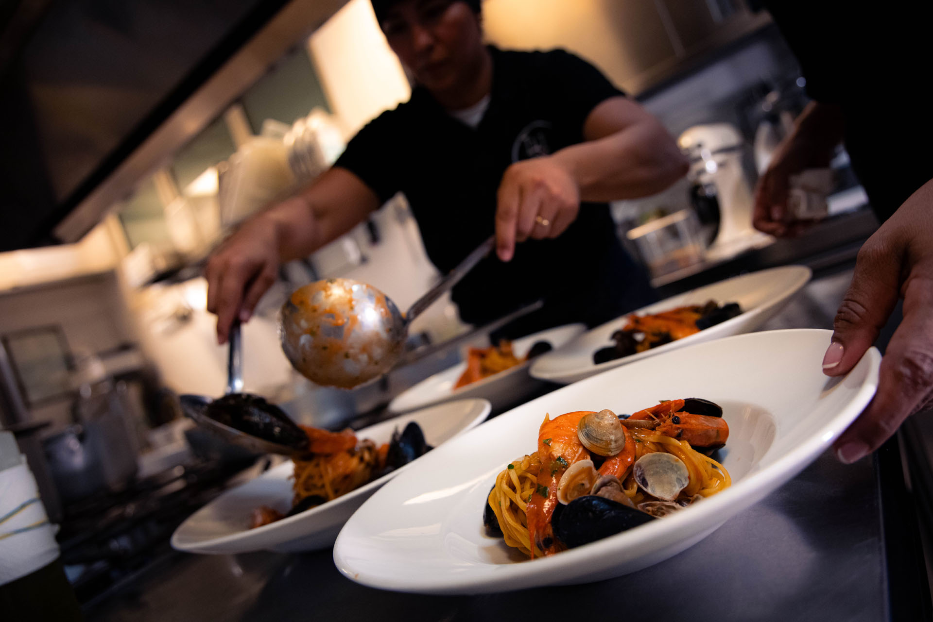 Lo staff impiatta pasta e cozze in cucina